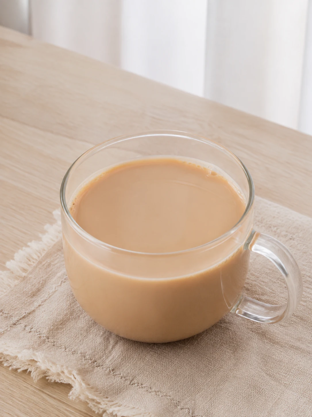 一杯清新基础奶茶，茶色均匀，置于自然窗光下的家庭餐桌